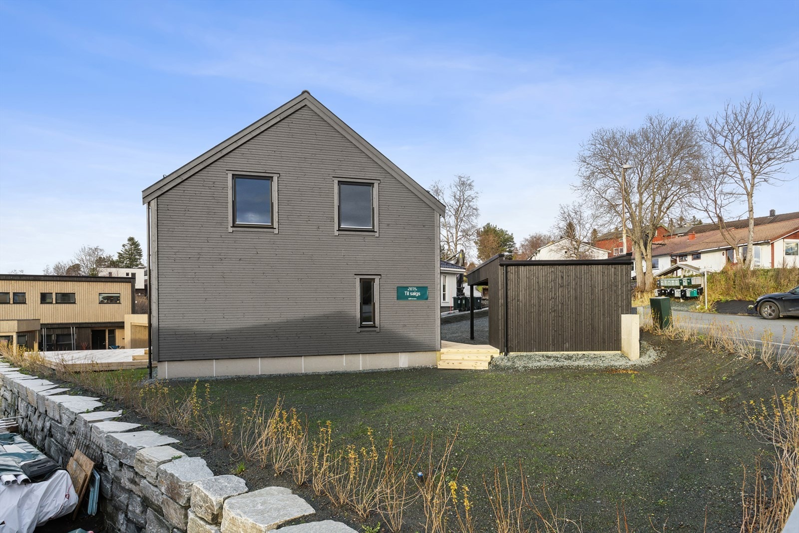 Det er sådd plen på tomten samt opparbeidet støttemur og hekk mot nabogrensen. Galleribilde
