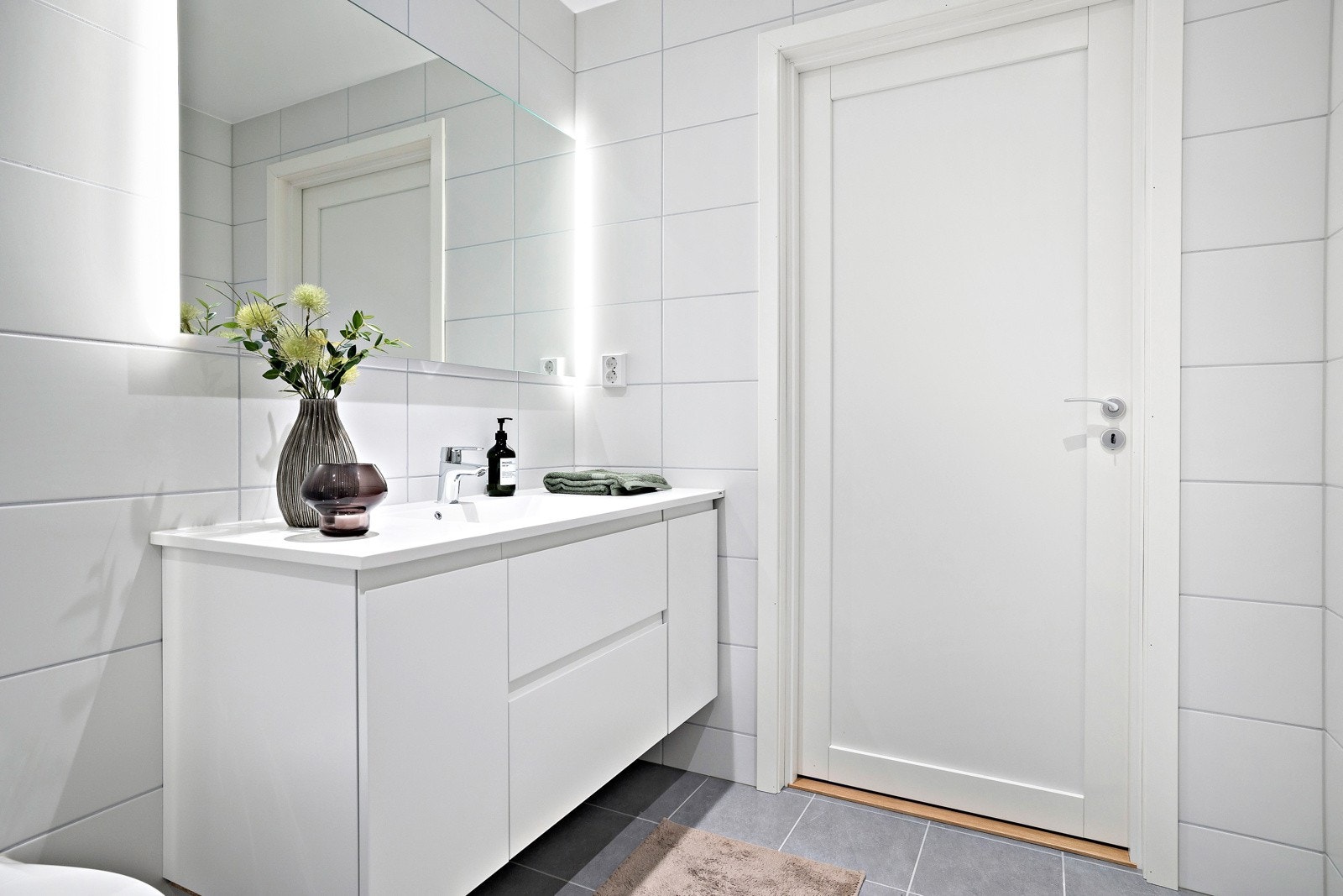 Det er godt med oppbevaringsplass i bred servantinnredning med både skap og skuffer. Varmtvann kommer fra fellesanlegg. Galleribilde