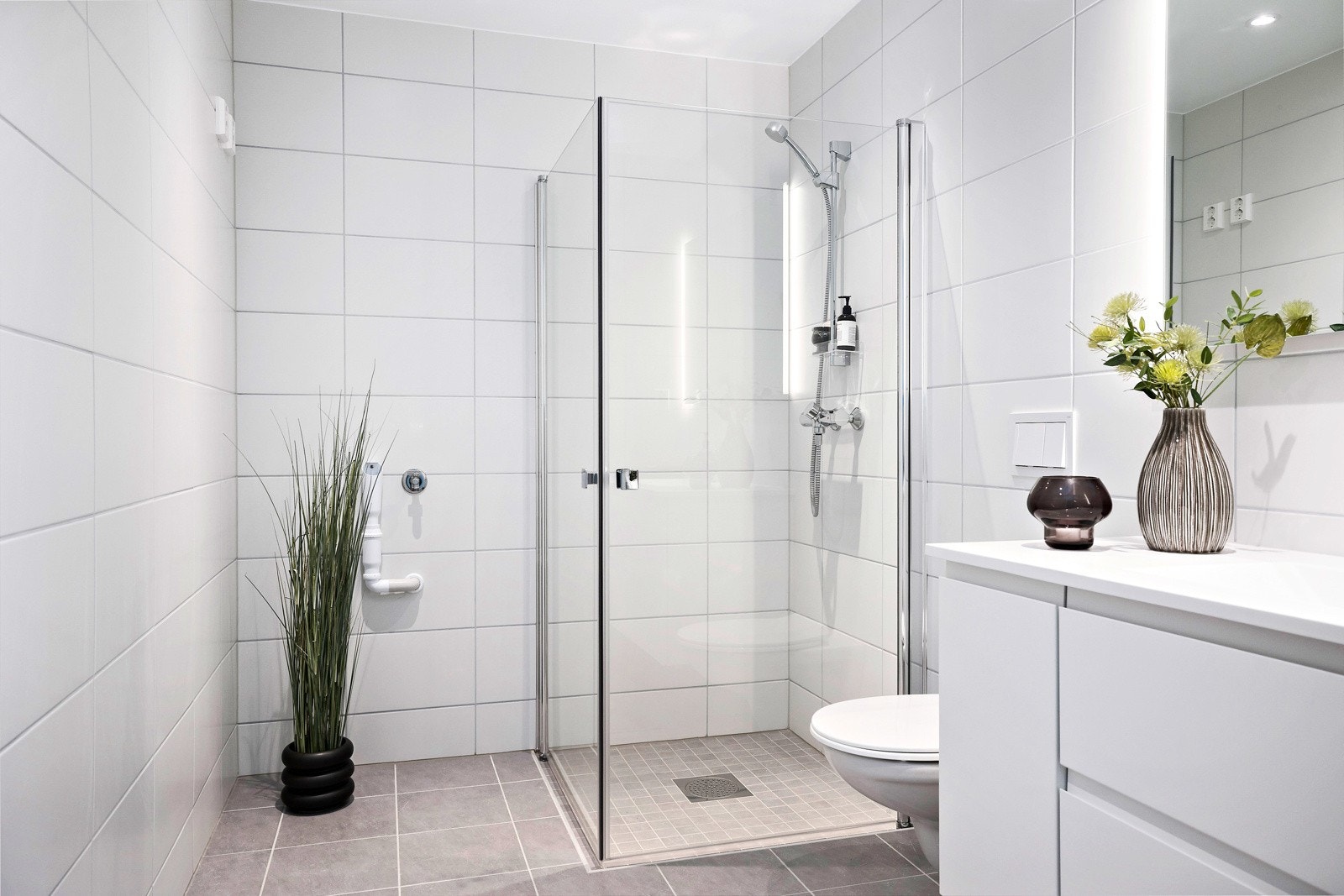 Badet er delikat og praktisk utformet, med flislagte overflater, elektrisk gulvvarme og opplegg for vaskemaskin. Galleribilde