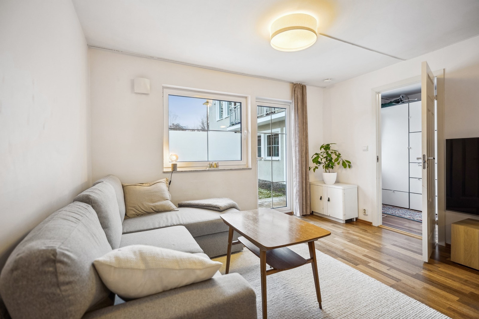 Lys og pen stue med godt lysinnslipp inn vinduene og verandadøren. Galleribilde