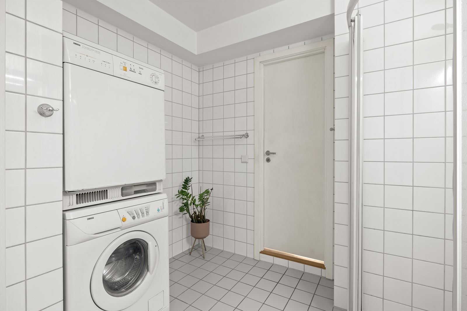 Det er dusjhjørne, baderomsmøbel, gulvstående toalett og opplegg for vaskemaskin og tørketrommel. Galleribilde