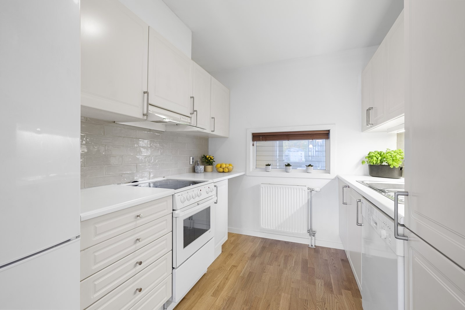 Kjøkkenet er tidløst med lyse, profilerte fronter og lys benkeplate. Galleribilde