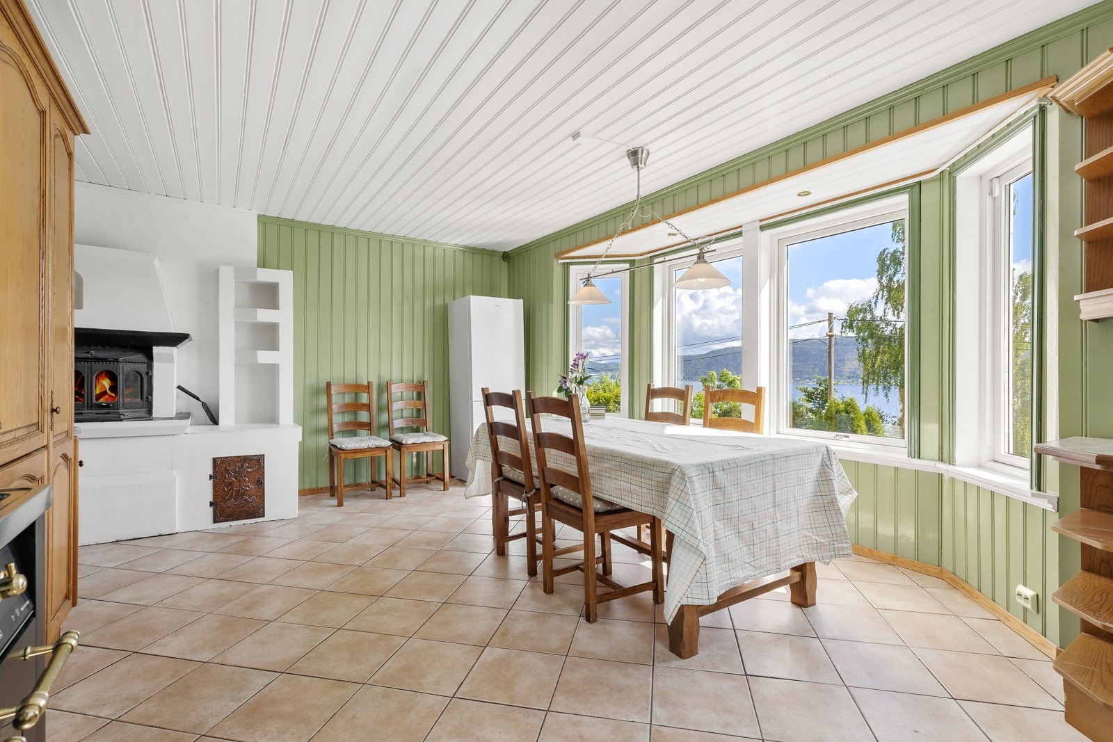 Kjøkkenet har god plass å tilby. Med elementpeis og store vindusflater som gir vær enkelt måltid nydelig utsikt. Galleribilde