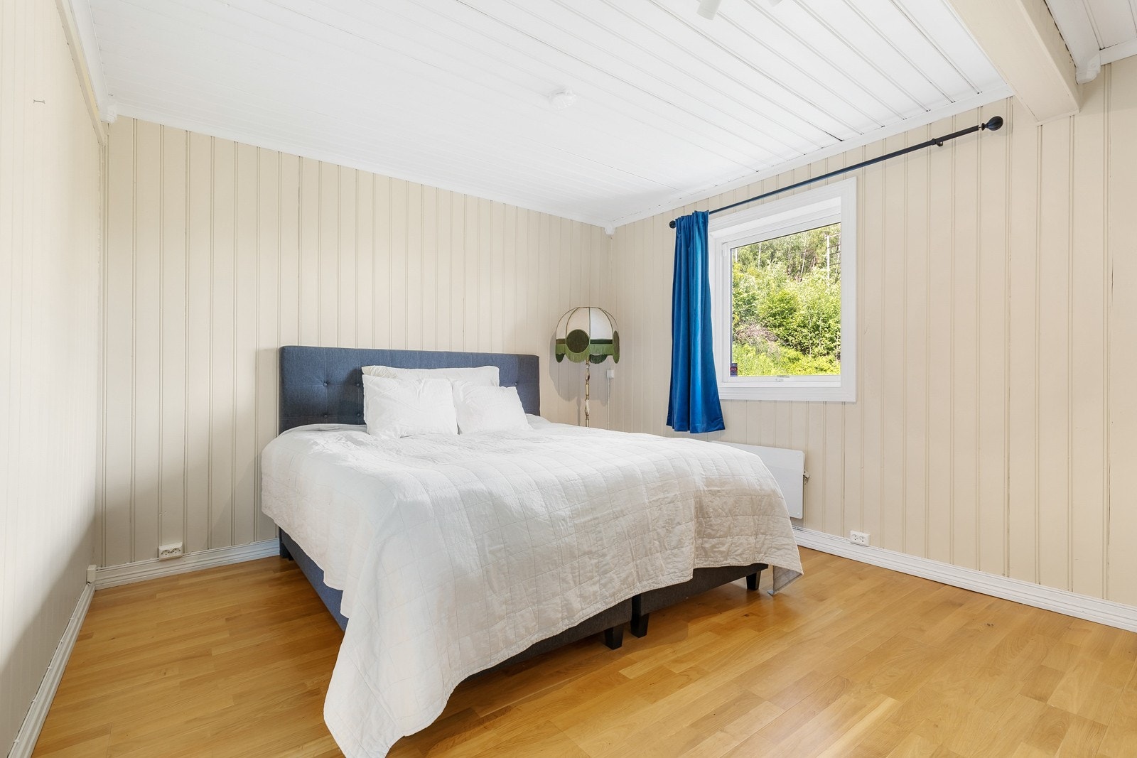 Soverom 2 har plass til stor seng og nattbord på vær sin side av sengen. Galleribilde