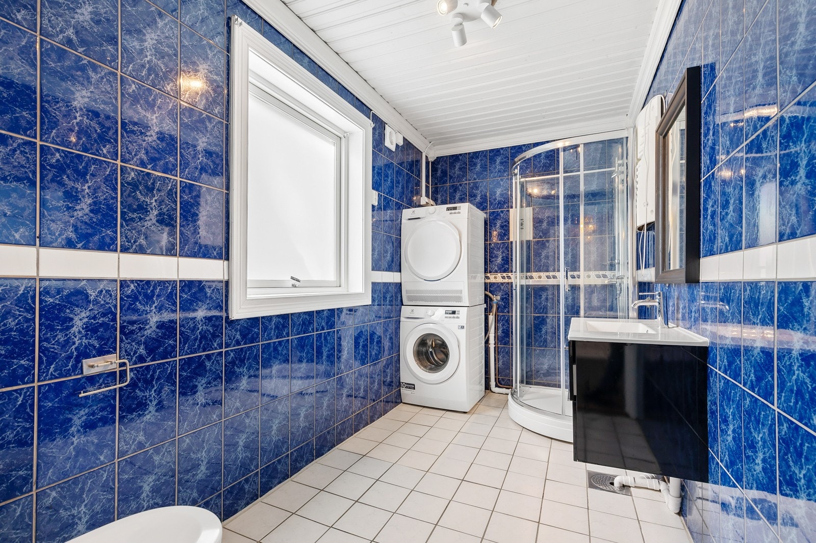 Bad 2 er av benkeskap med glatte fronter. Speil over servant. Dusjkabinett- Servant og opplegg for vask & tørk. Galleribilde