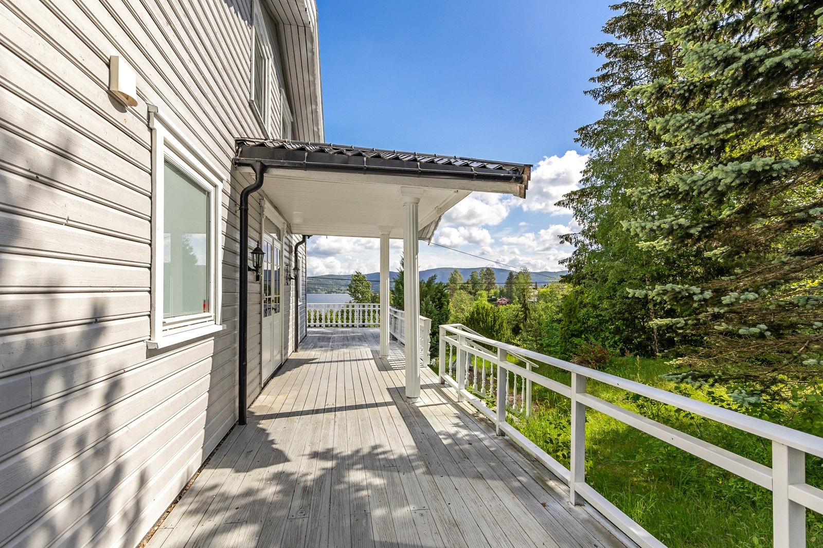Terrasse som strekker seg rundt store deler av eneboligen. Galleribilde