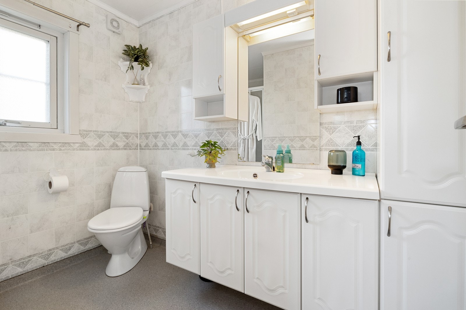 Baderom med belegg på gulvet og plater på vegger. Galleribilde