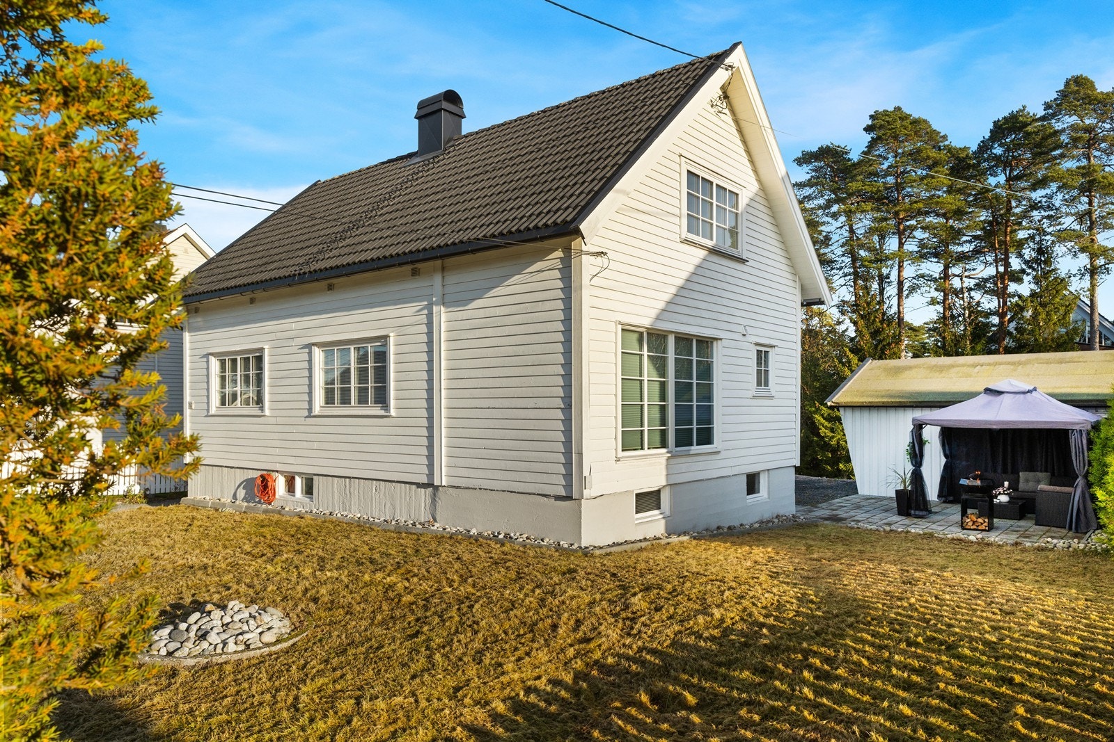 Tomten er opparbeidet med gressplen og beplantning. Det er gruset gårdsplass med plass til flere biler. Galleribilde