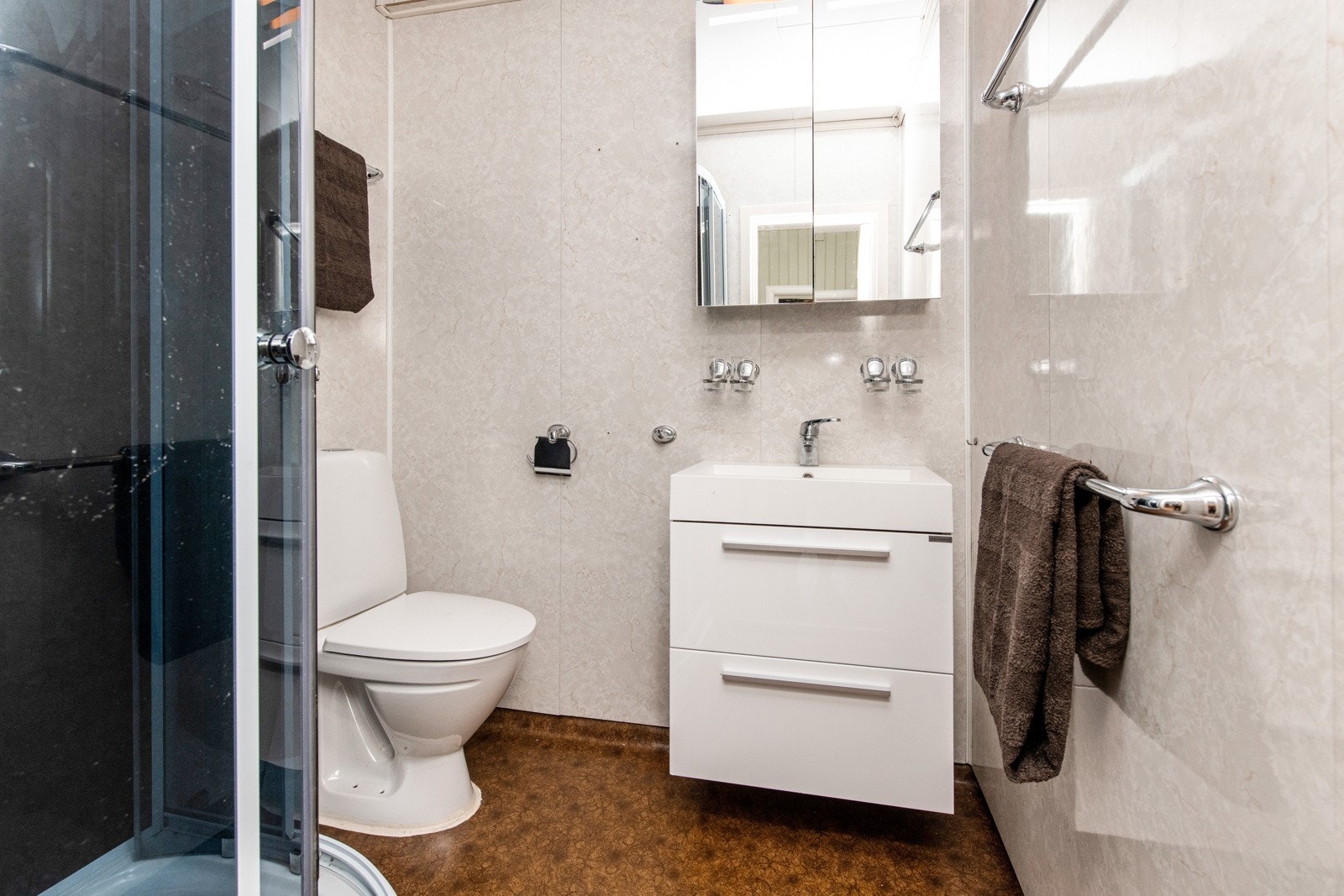Badet i andre etasje er innredet med gulvvarme, dusjkabinett, gulvstående toalett og servantinnredning med skuffer, samt speil med dører. Galleribilde