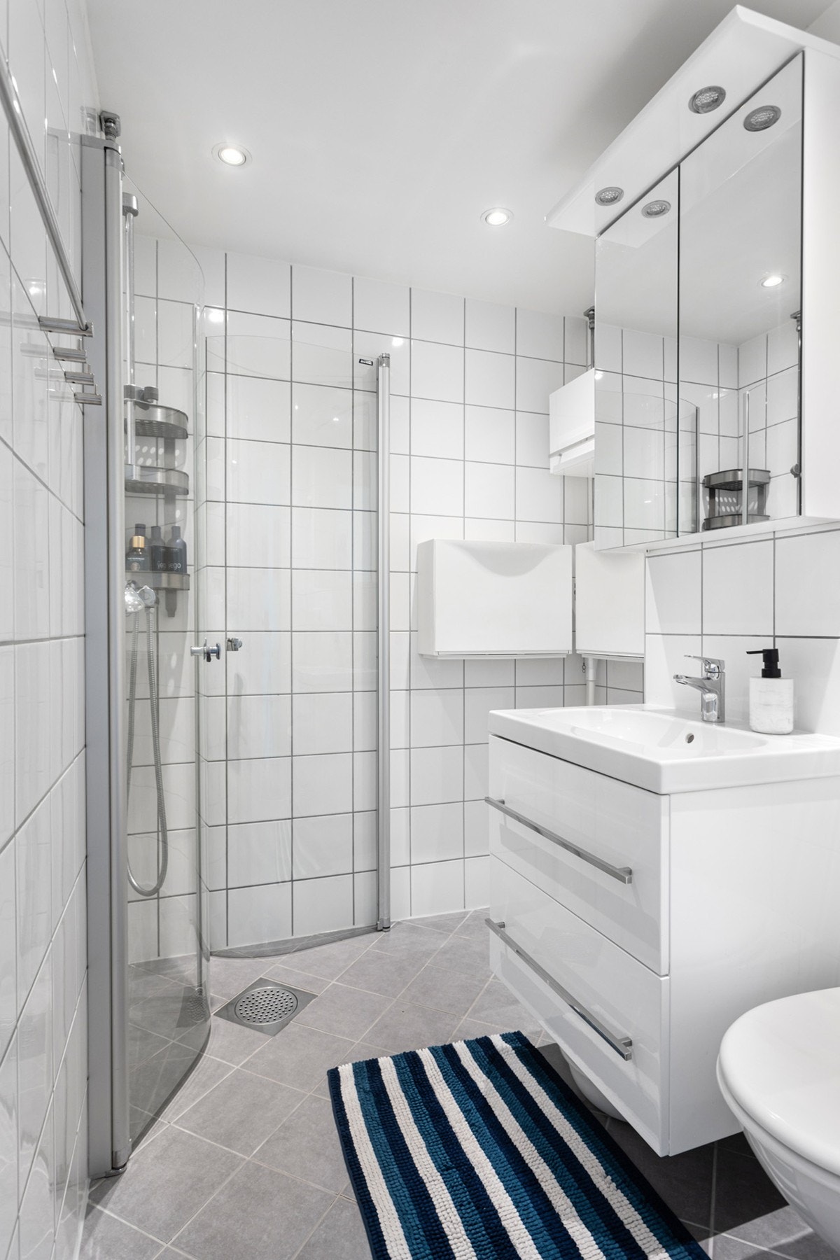 Flislagt bad med varme i gulv og downlights i himling fra 2011. Galleribilde