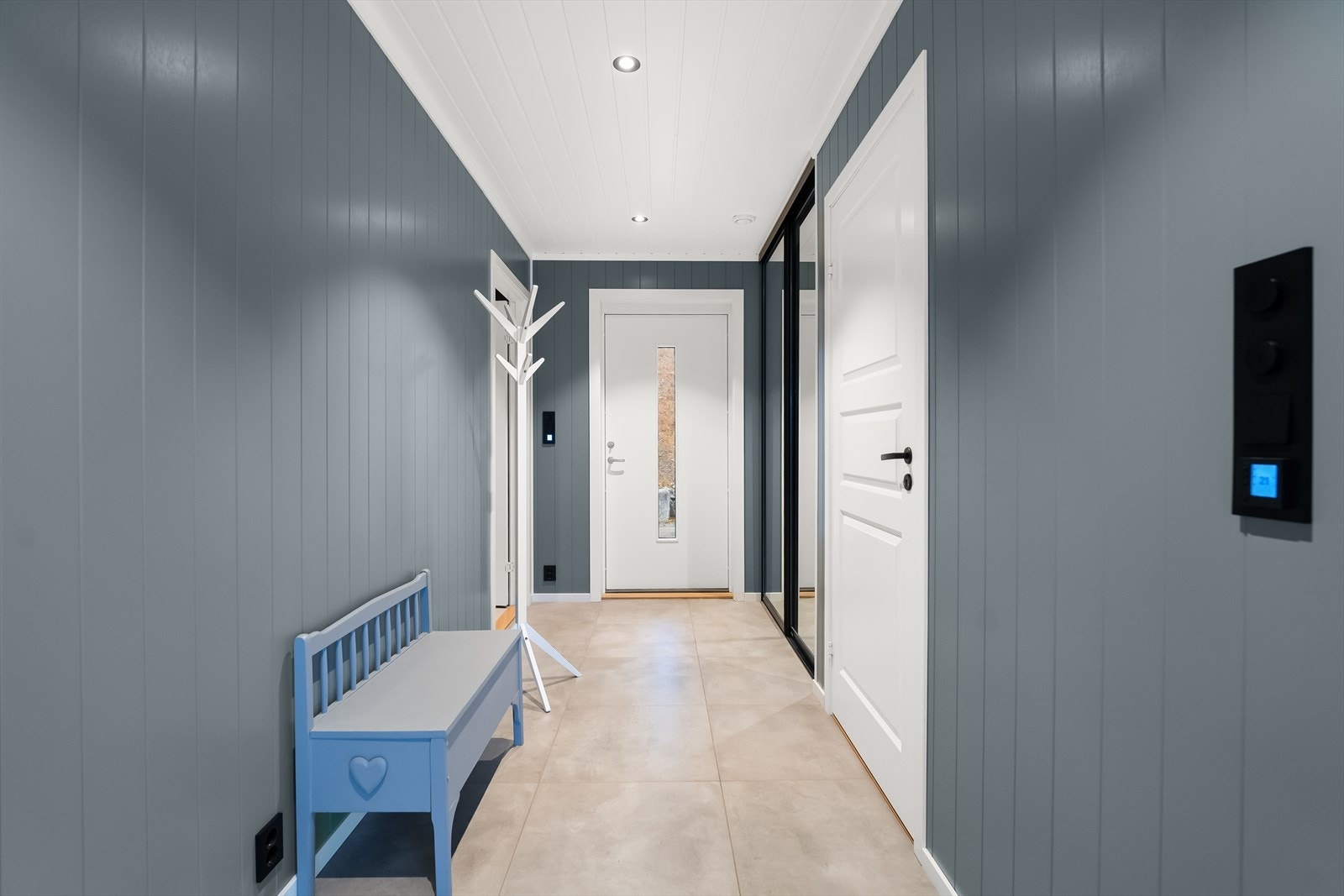 Romslig og flislagt entre med skyvedørsgarderobe. Galleribilde