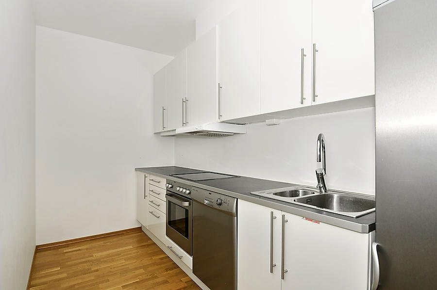 Lyst og pent kjøkken med medfølgende hvitevarer Galleribilde