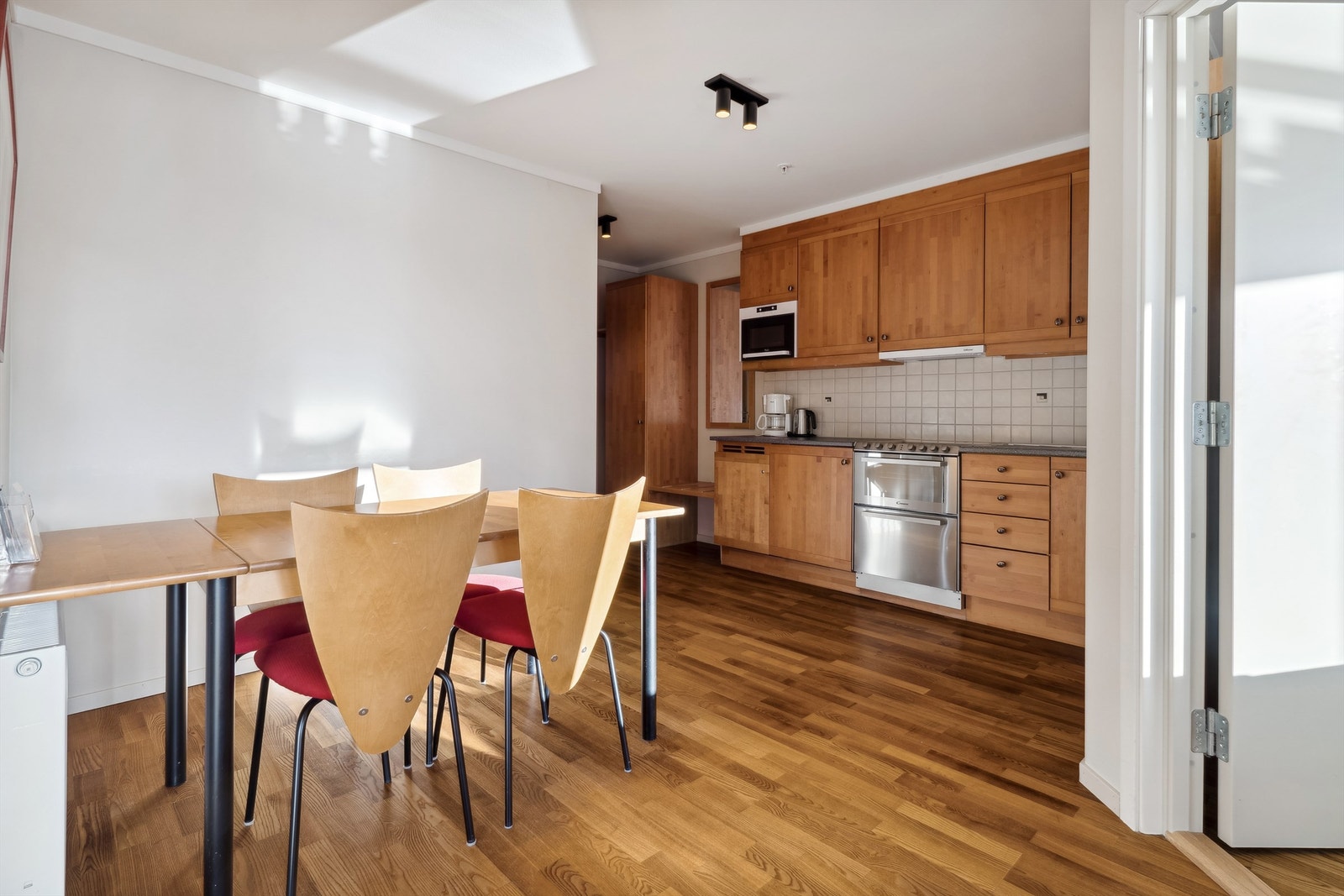 Romslig oppholdsrom med kjøkkeninnredning og spiseplass. Galleribilde