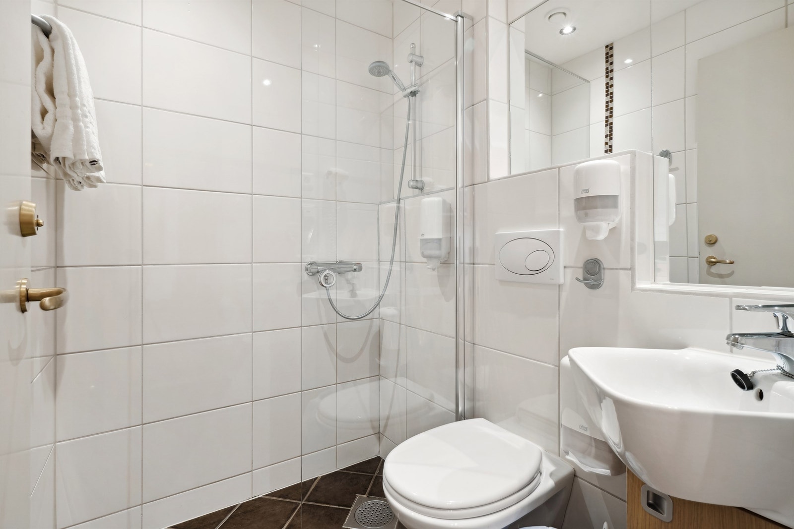 Badet i rom 410 er flislagt og utstyrt med vegghengt toalett, servant med underskap og dusj med glassvegg. Oppvarming med gulvvarme. Galleribilde