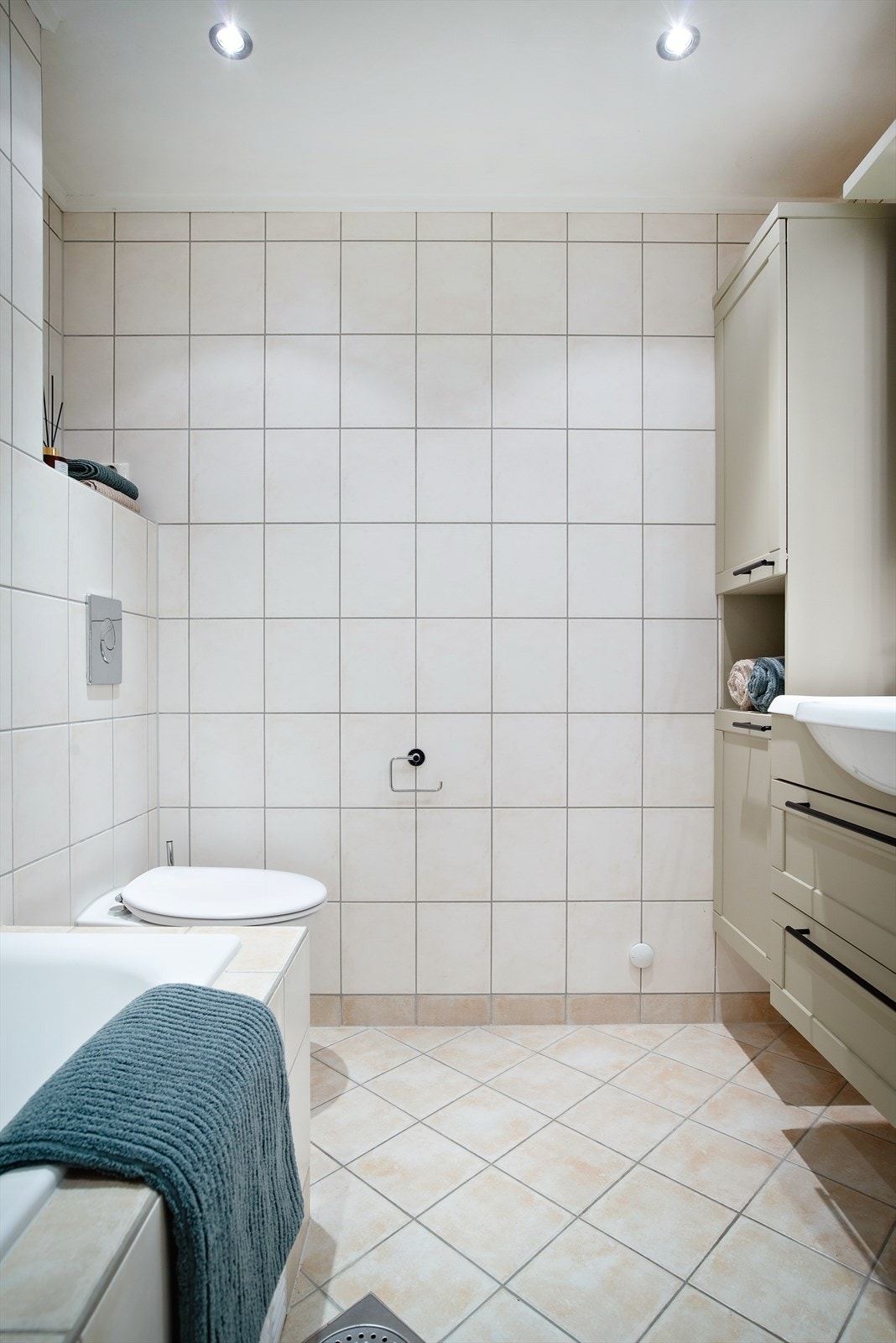 Det flislagte badet er stilfullt og funksjonelt, med innredning som inkluderer toalett, servant med ettgreps blandebatteri, og et badekar utstyrt med dusjarmatur. Galleribilde