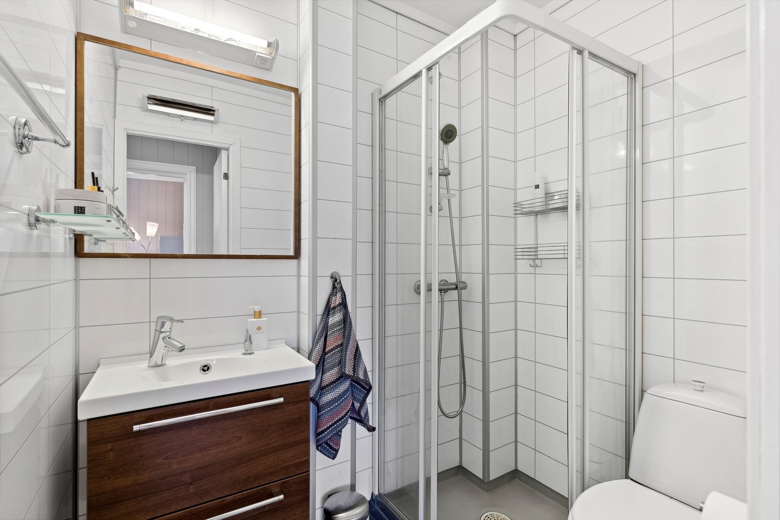 På badet er det toalett, varmekabler og et dusjhjørne med skyvedører. Leiligheten har også tilgang på et felles vaskerom i kjelleren. Galleribilde