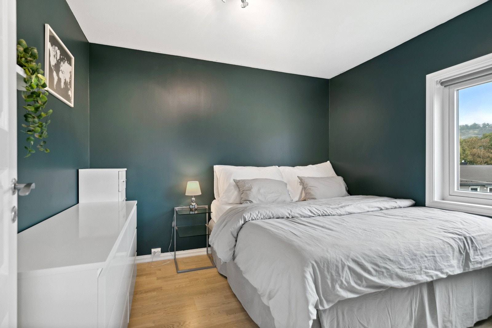 På hovedsoverommet er det plass til både dobbeltseng og annet møblement. Veggene er malt i en mørk og tidsriktig grønn nyanse, noe som bidrar til en avslappende atmosfære. Galleribilde