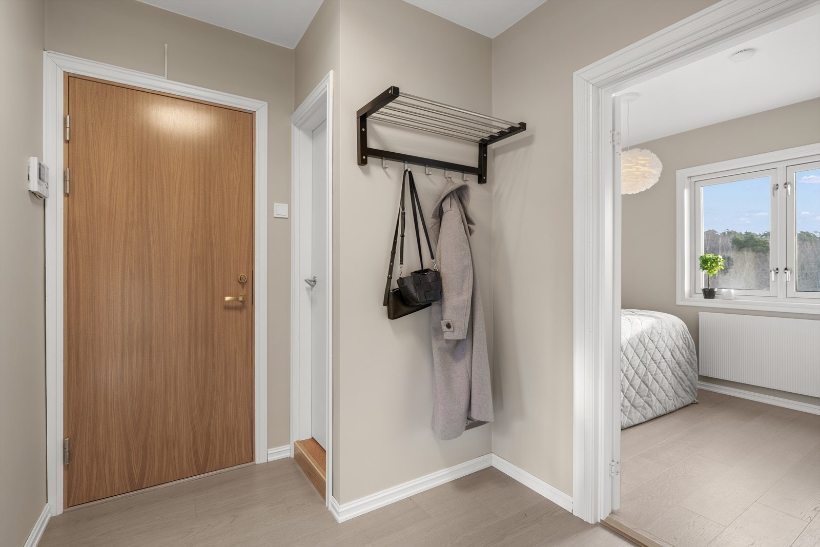 Entrè med plass til sko og yttertøy. Fra entrè er det direkte adkomst til toalettrom og leilighetens to soverom Galleribilde