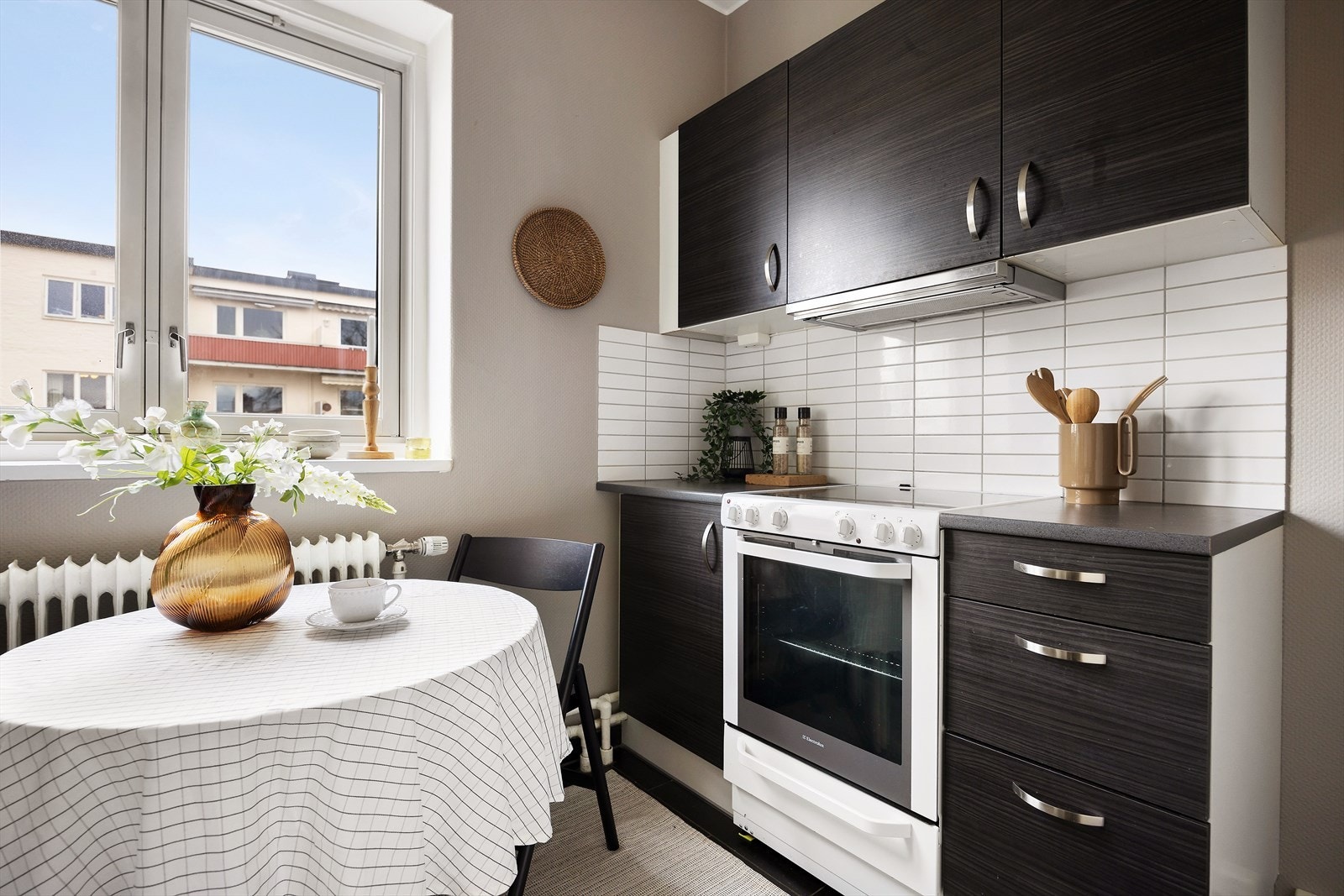 Mørk kjøkkeninnredning med glatte fronter og benkeplate av laminat. Vaskemaskin og stekeovn medfølger salget. Galleribilde