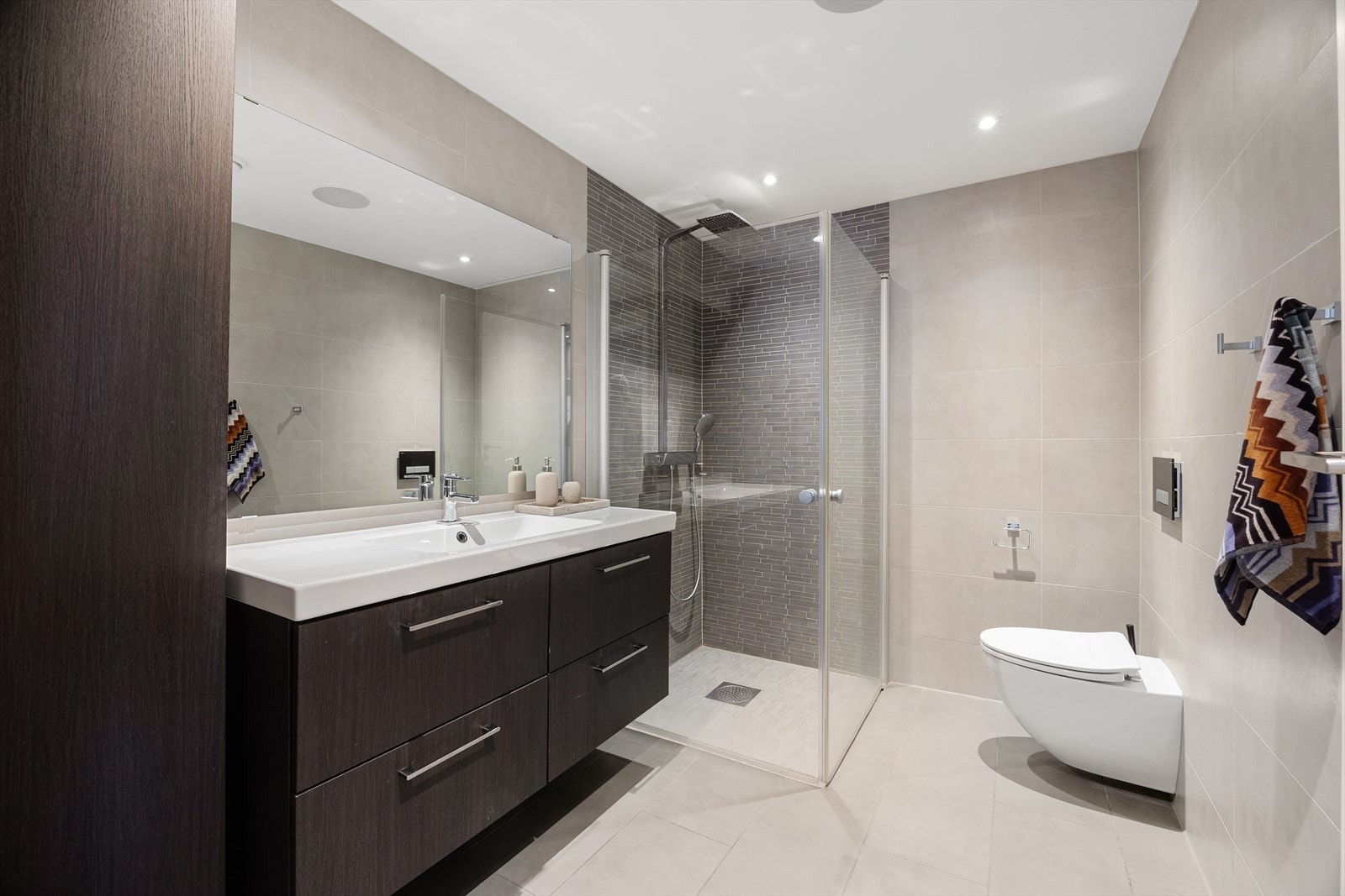 To lekre bad som er helfliset med tidløse fliser og med innlagte varmekabler Galleribilde