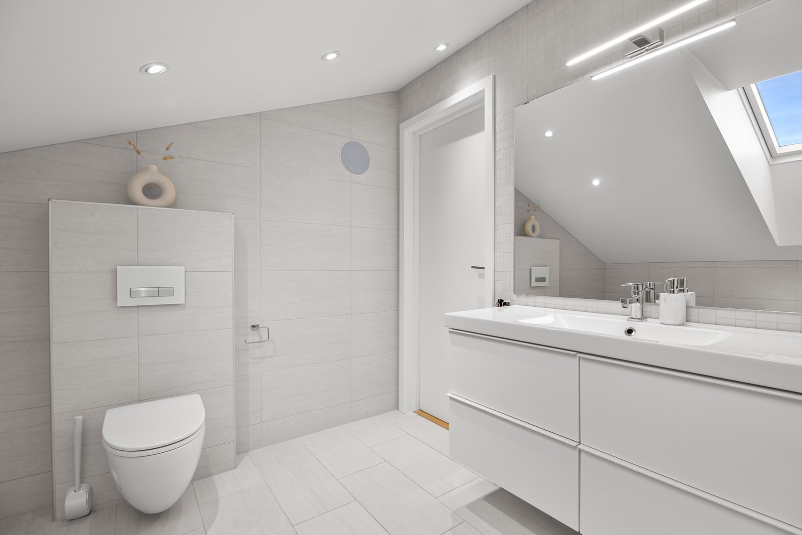 Flott baderomsinnredning med heldekkende servant og stort speil. Galleribilde