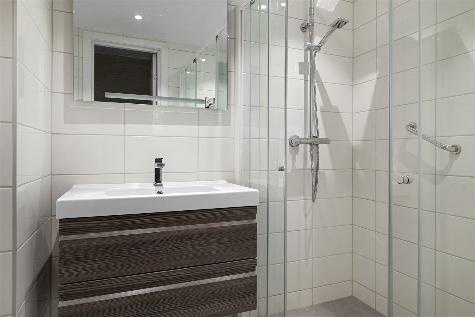 Slett baderomsinnredning med skuffer og speil med lys Galleribilde