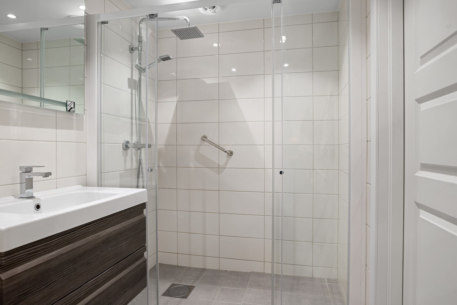 Badet har stor dusj med skyvedører i glass Galleribilde