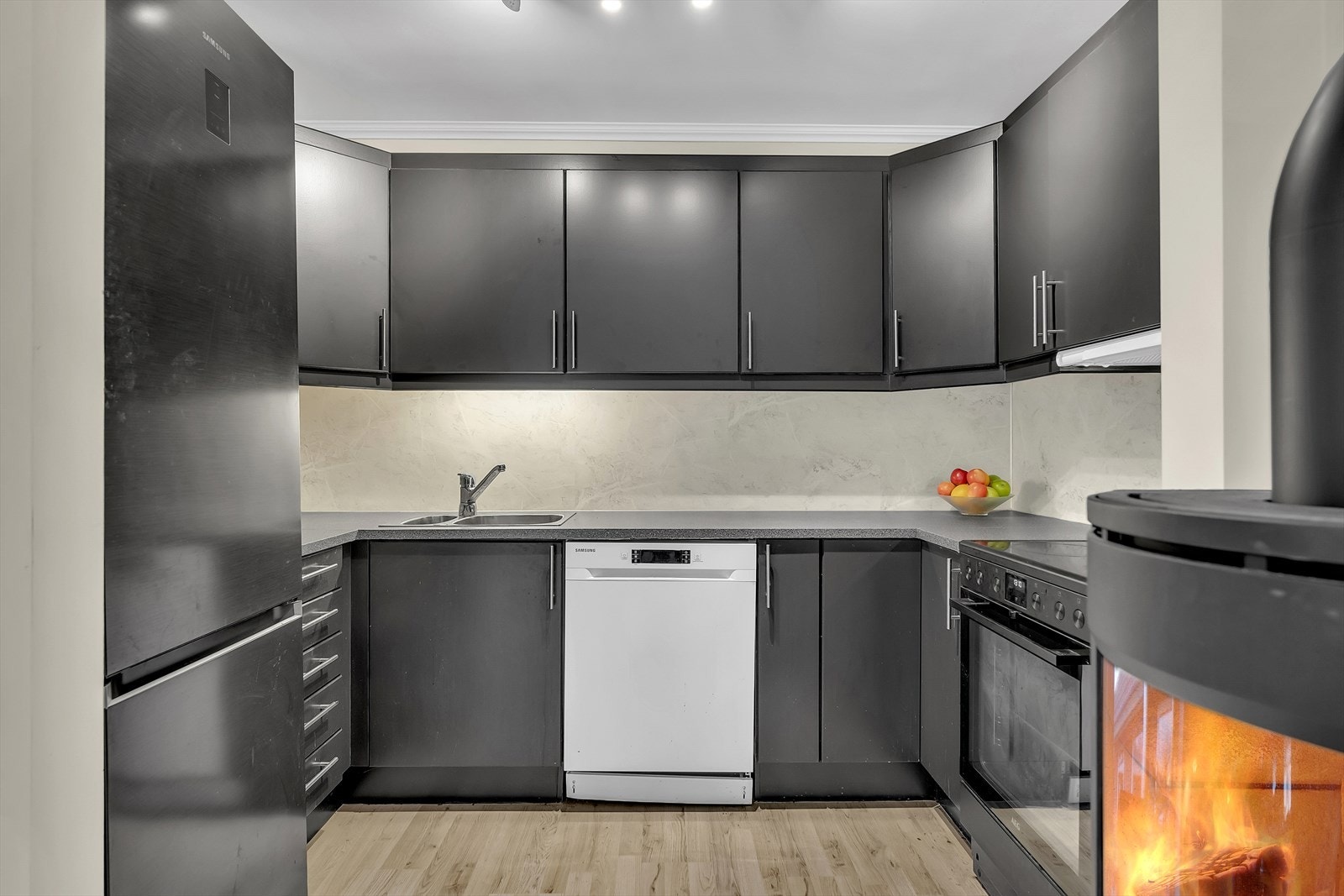 Stilrent kjøkken med sorte glatte overfalter, benkeplate i laminat og tidsriktig kitchenboard. Galleribilde