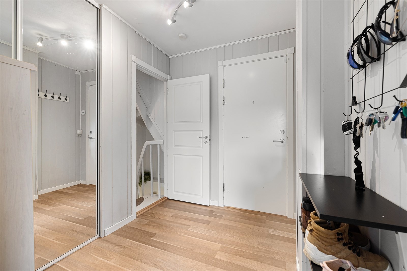 Boligen har en lys og romslig gang innredet med skyvedørsgarderobe Galleribilde