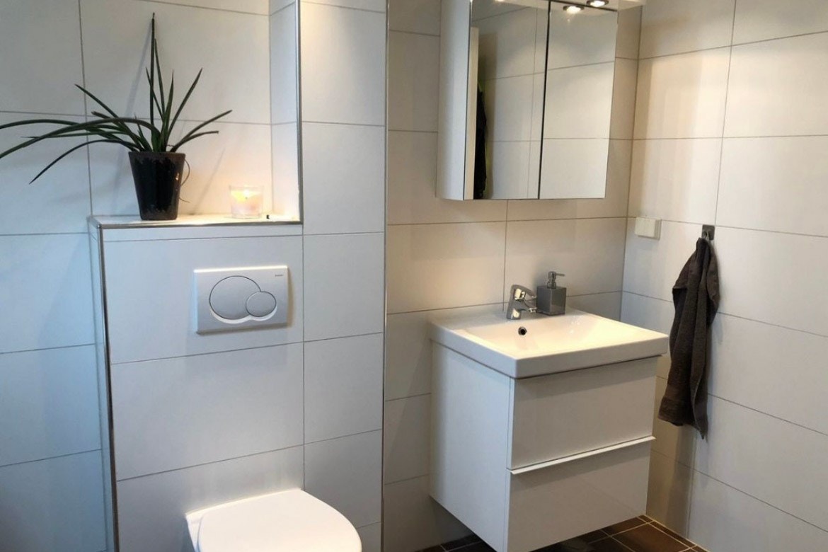 Badet er innredet med servant i innredning med skuffer, speilskap, dusjhjørne og toalett. Varmekabler i gulv. Opplegg til vaskemaskin Galleribilde