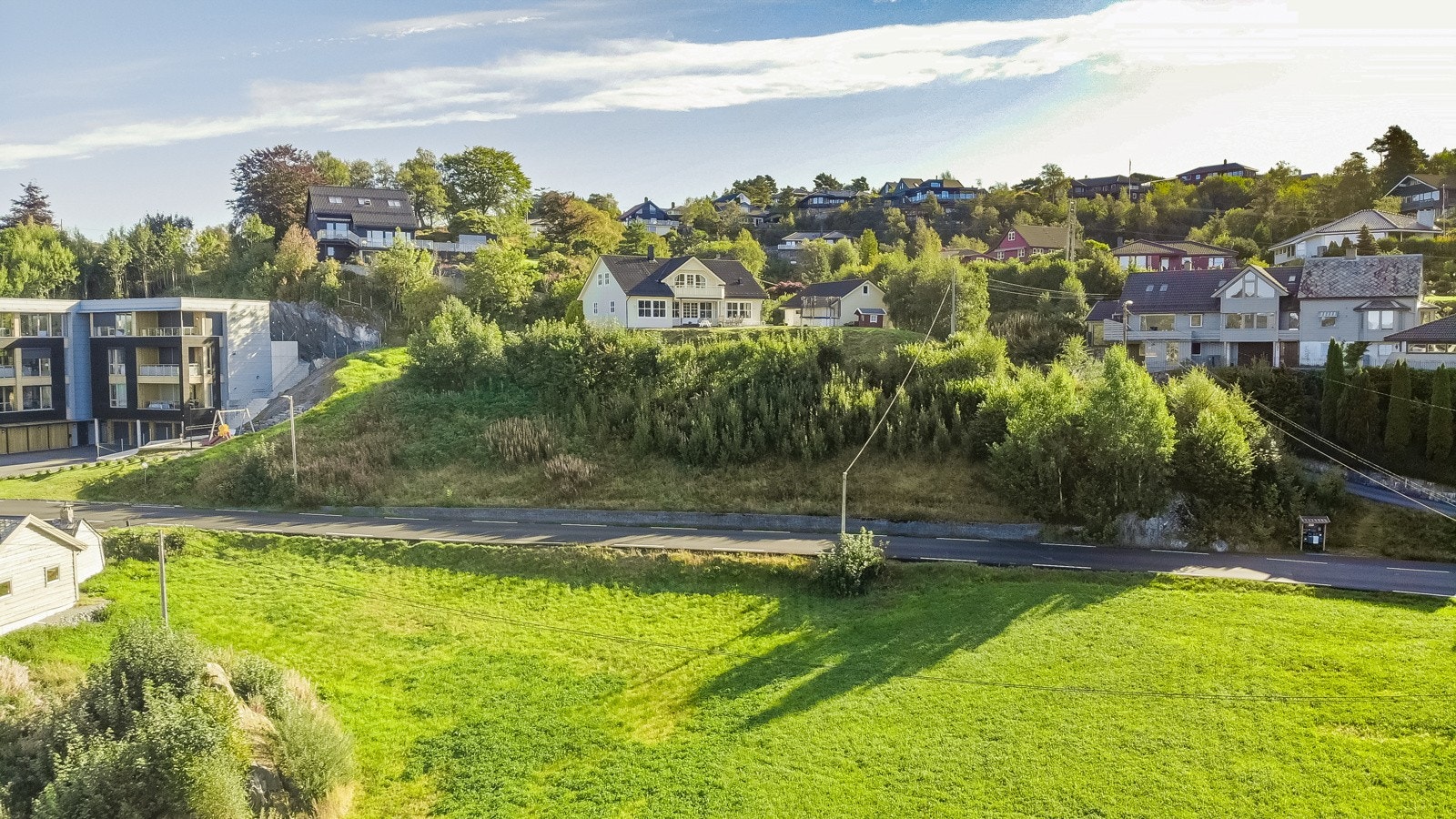 Mellom tomten og leilighetsbygget på nabotomten går det en snarvei opp til skole, barnehage og idrettsplass. Galleribilde