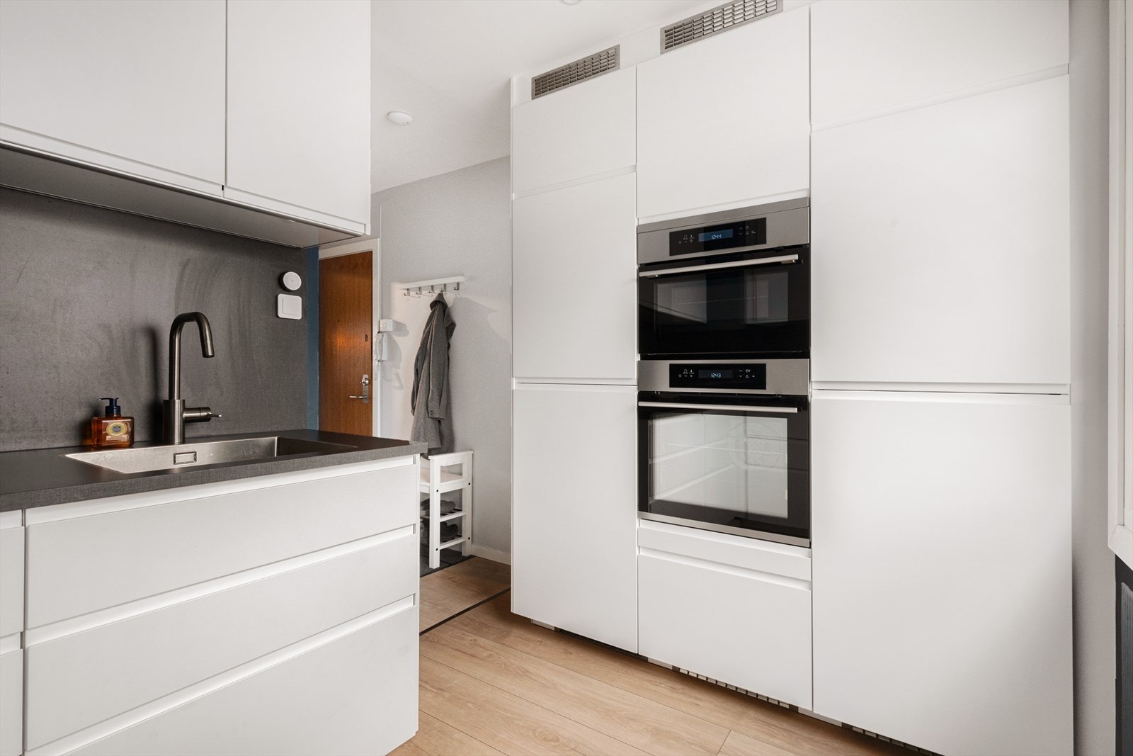 Alle hvitevarer er integrert: Stekeovn, mikrobølgeovn, oppvaskmaskin, samt kjøleskap og fryseskap i full høyde. Galleribilde