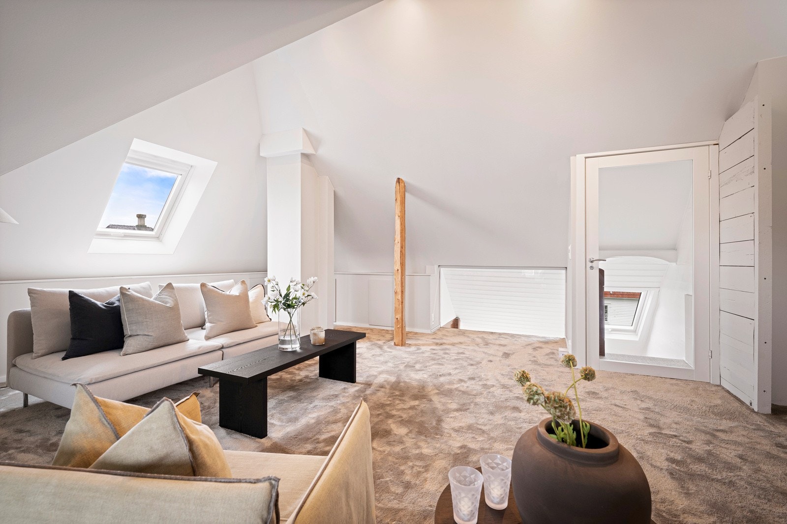 Stuen har heldekkede gulvteppe i en delikat beigefarge og slette, hvitmalte vegger. Galleribilde