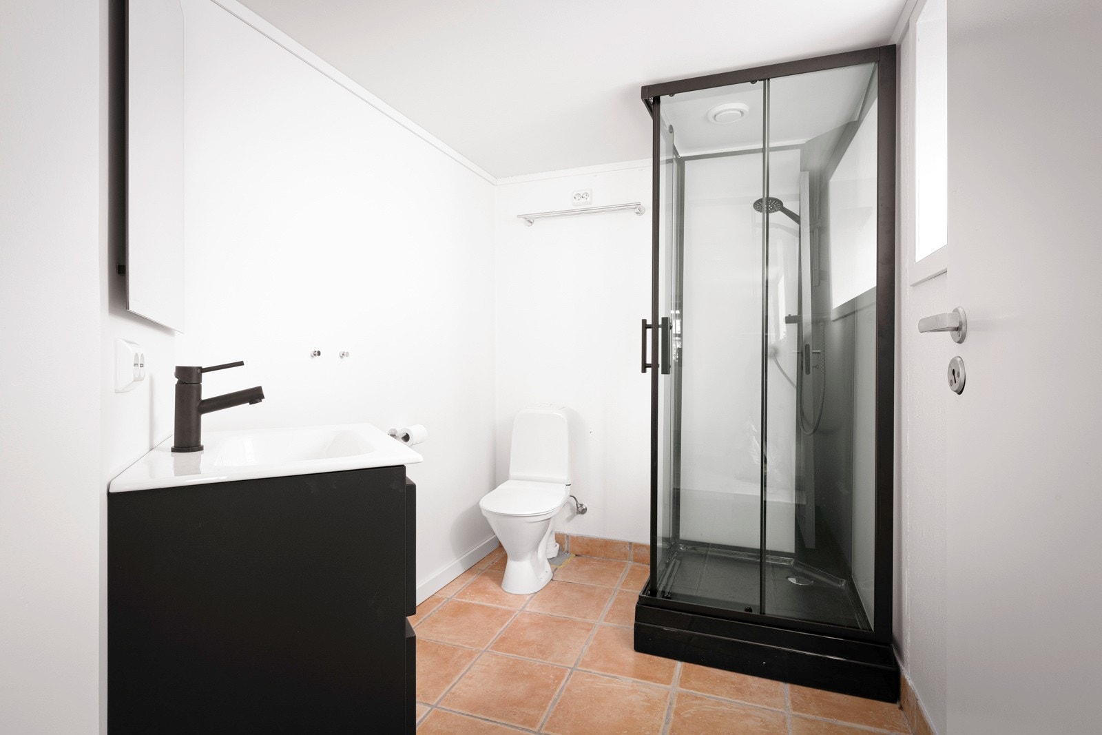 Badet har gulvmontert toalett og er oppgradert i 2024 med malte veggflater, samt ny innredning og dusjkabinet i sort design. Galleribilde