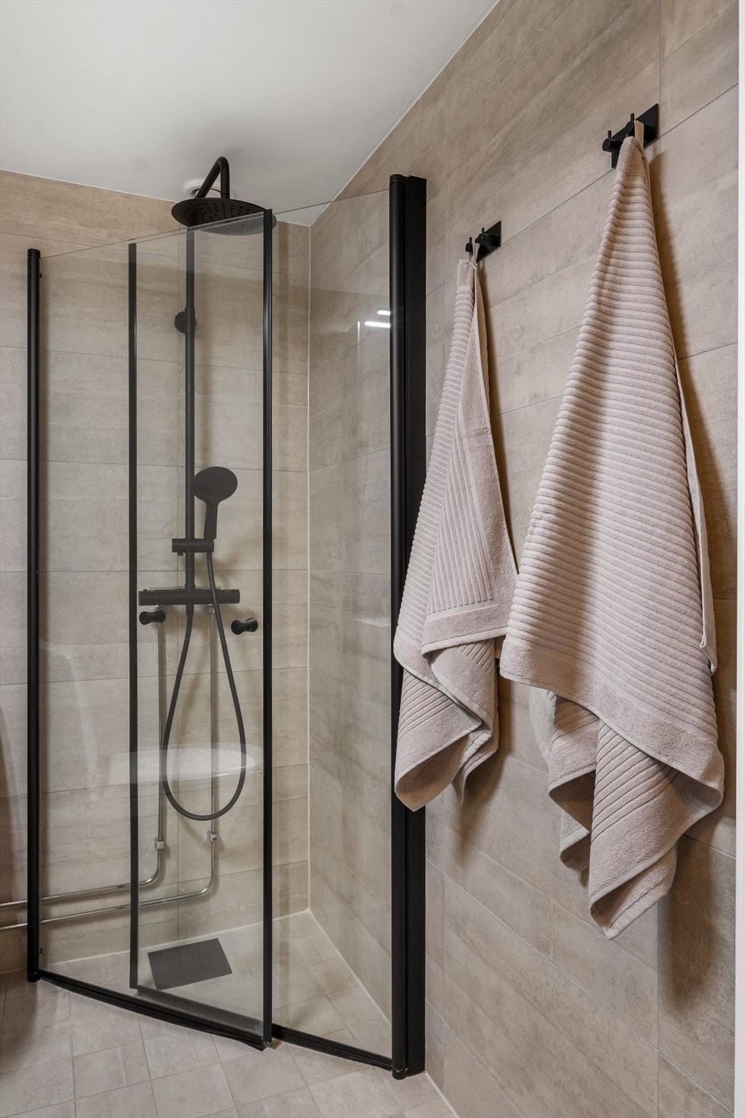 Badet har ny innredning med helstøpt servant, speilskap med belysning, toalett og dusjvegger i hjørnet. Galleribilde
