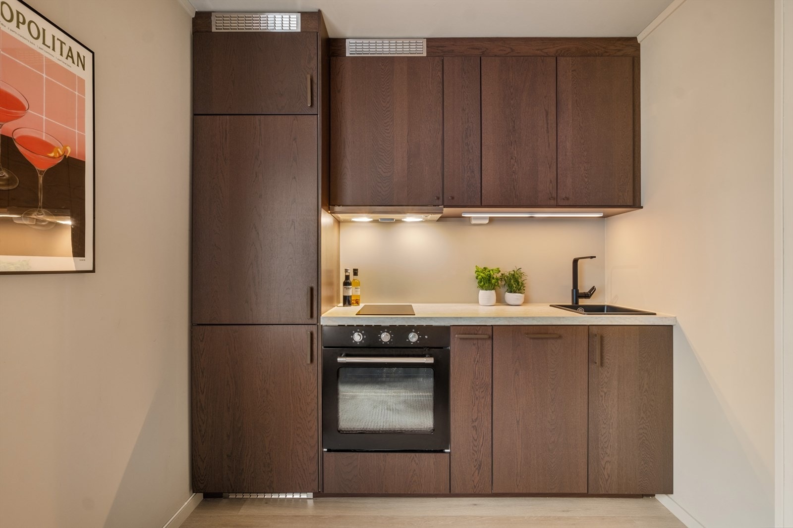 Kjøkkenet har ny moderne innredning med glatte finerte mørke fronter. Benkeplaten er av laminat med nedfelt vaskekum og platetopp. Det er integrert kjøl/fryseskap, oppvaskmaskin og stekeovn. Galleribilde