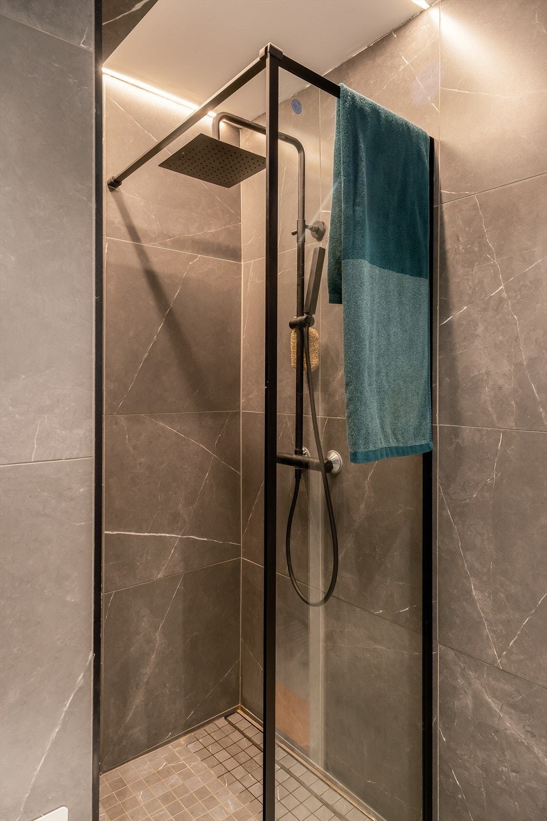 Badet har eksklusivt uttrykk, speil med lysjustering og sorte detaljer. Galleribilde
