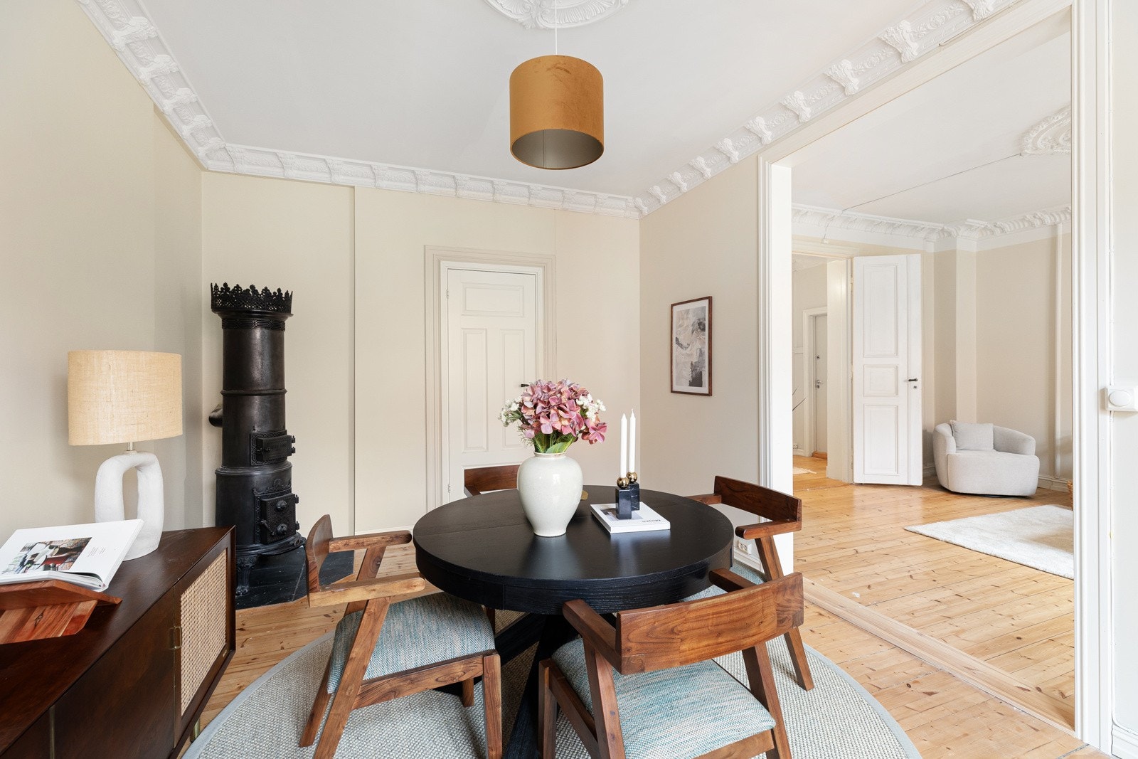 Frittstående vedovn i stuen med tradisjonell, dekorativ stil som komplimenterer de klassiske detaljene Galleribilde