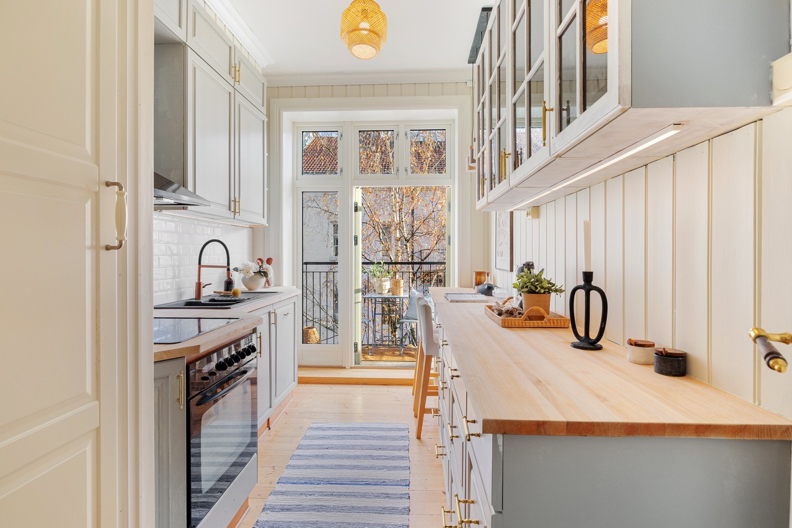 Lys kjøkkeninnredning med profilerte, malte fronter og benkeplate i heltre Galleribilde