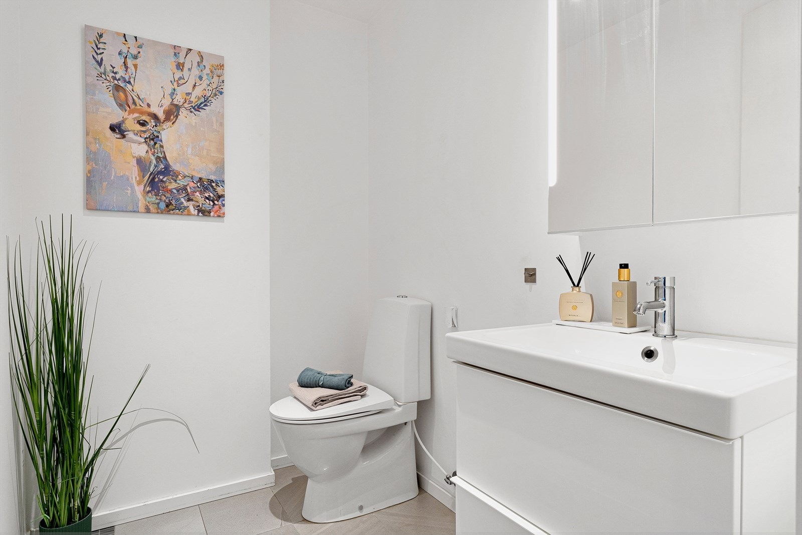 Toalettrommet er innredet med toalett og baderomsinnredning med heldekkende servant samt belyst speil. Galleribilde