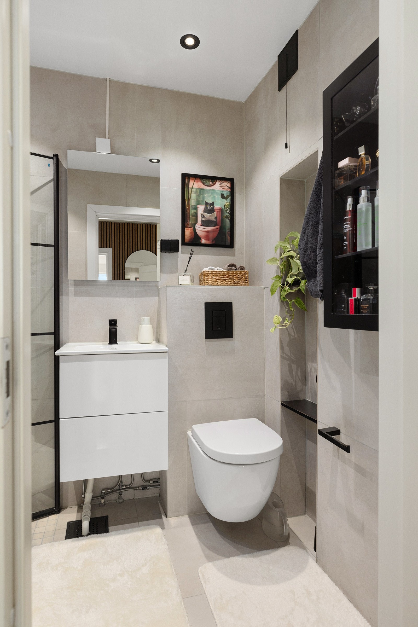 Innbydende bad med vegghengt klosett, sorte detaljer etc Galleribilde