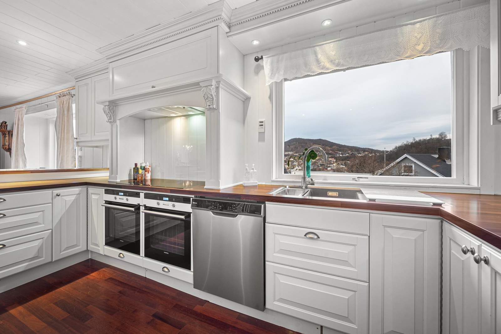 Hvite, profilerte fronter, benkeplate av laminat og vaskekum i slitesterkt komposittmateriale Galleribilde