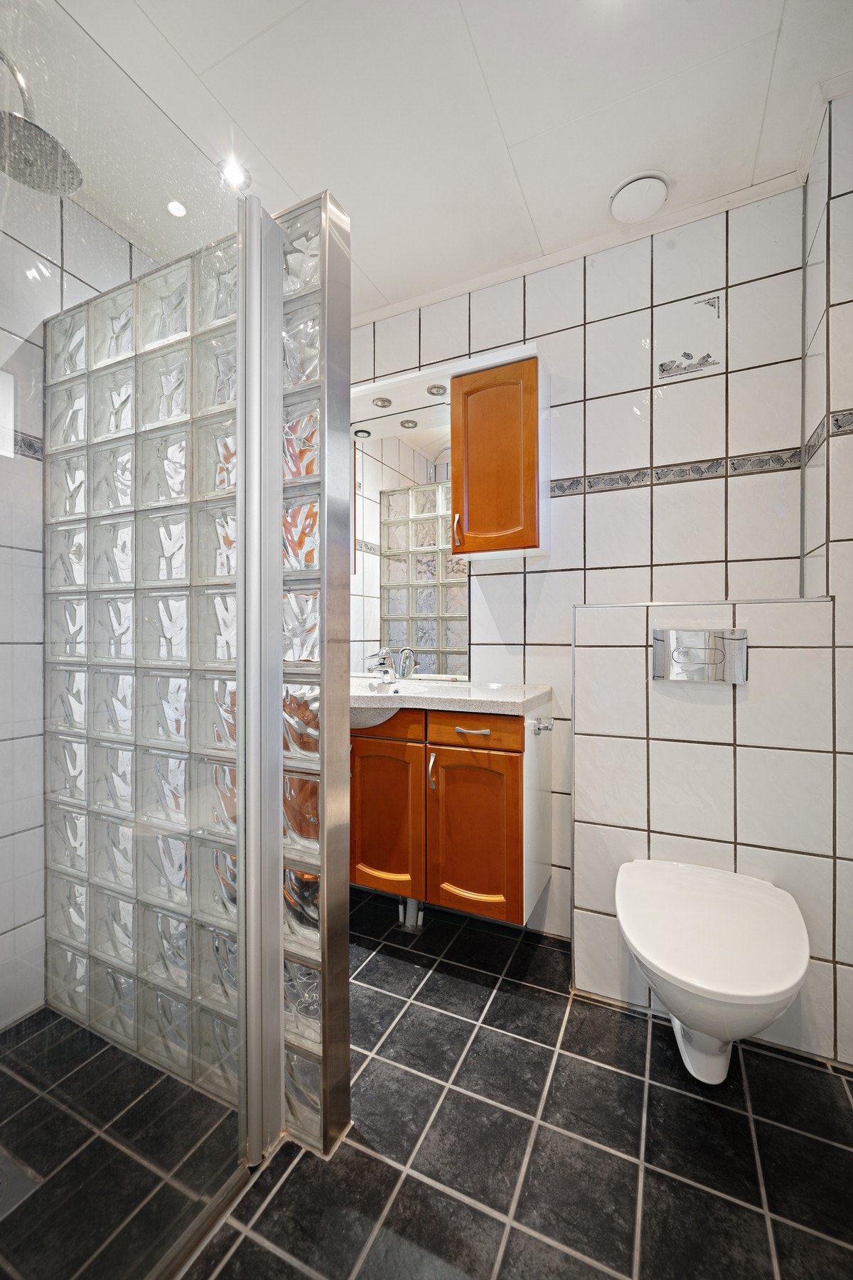 Her er det servantinnredning, dusjhjørne med glassvegg og wc Galleribilde