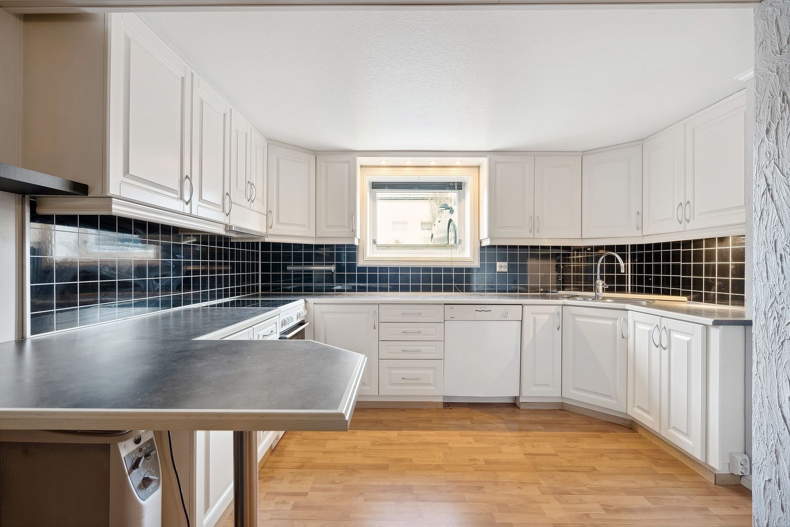 Romslig kjøkken med godt utbygget skap og benkeplass. Galleribilde