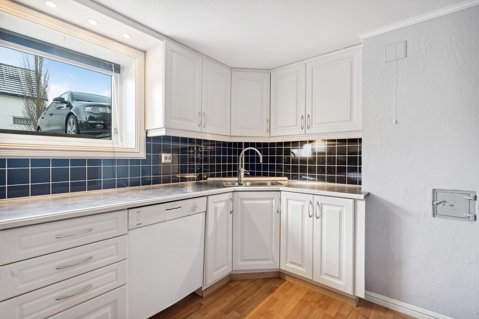 Kjøkkeninnredning i lys profilert utførelse og plater over benk. Galleribilde