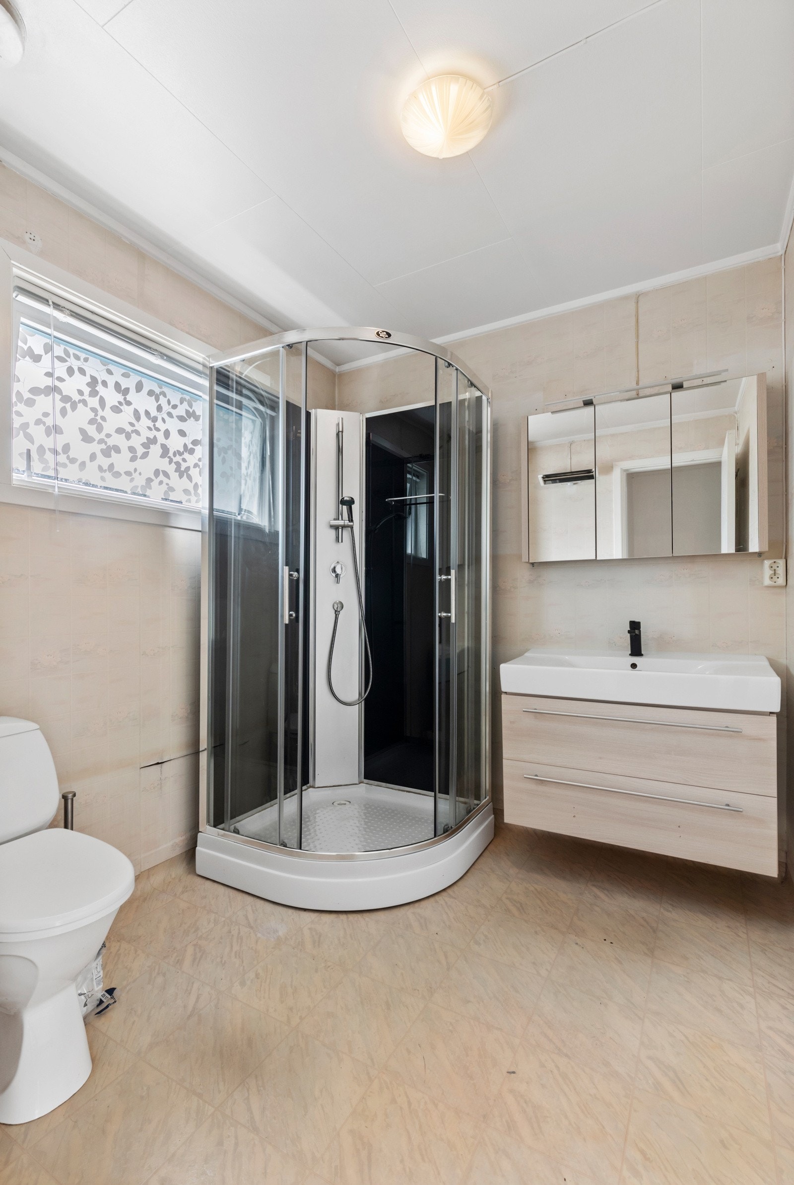 Bad holdt i lyse farger farger med en nyere baderomsinnredning og dusjkabinett. Galleribilde