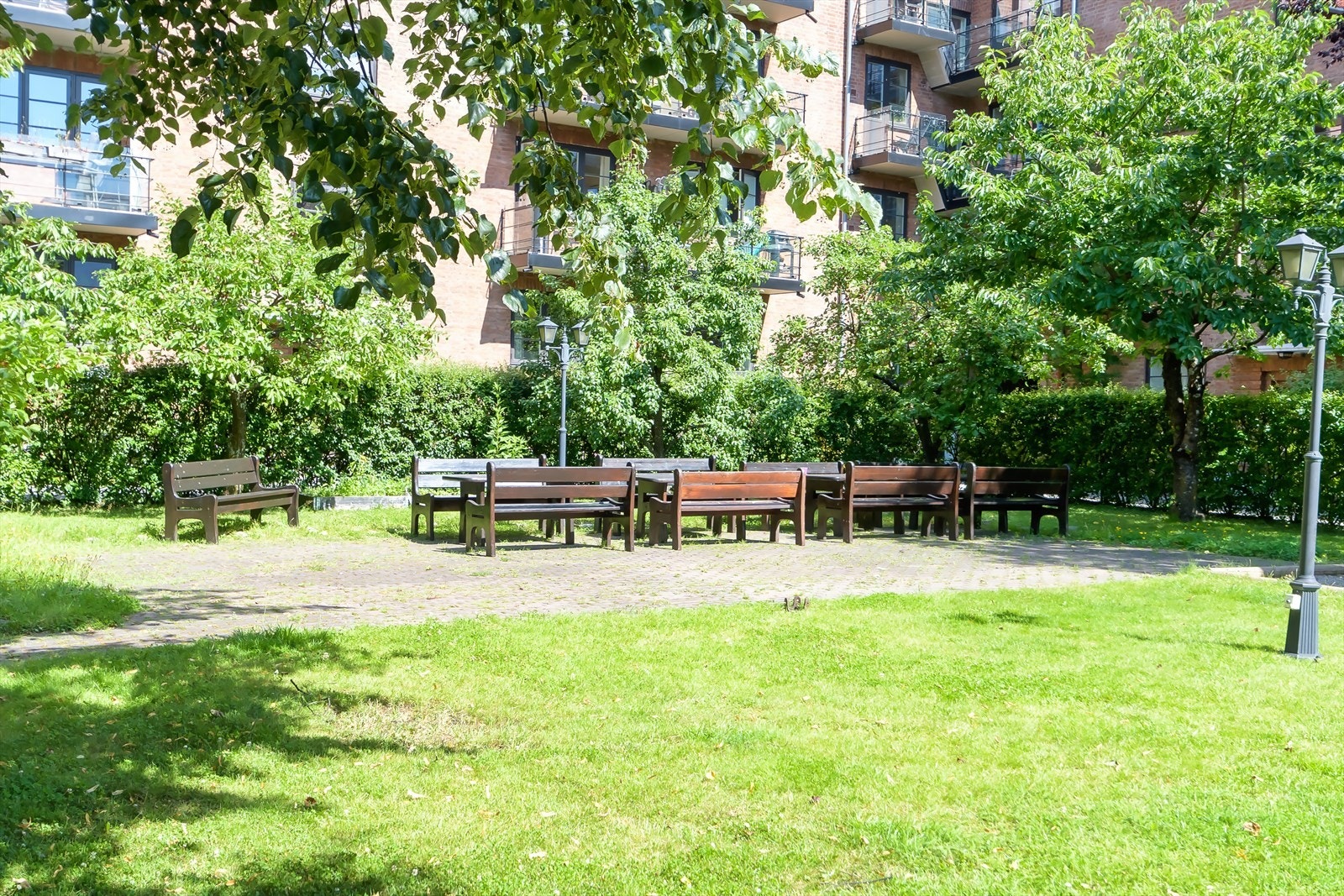 Nydelig bakgård som ligger skjermet til med lekeapparater, sittegrupper og flott beplantning Galleribilde