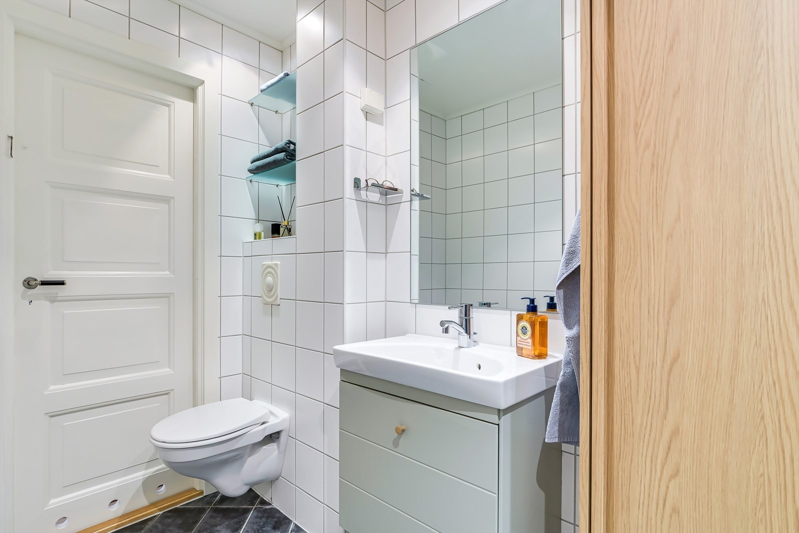 Baderomsinnredningen består av servant i skuffeseksjon, høyskap og veggmontert toalett Galleribilde