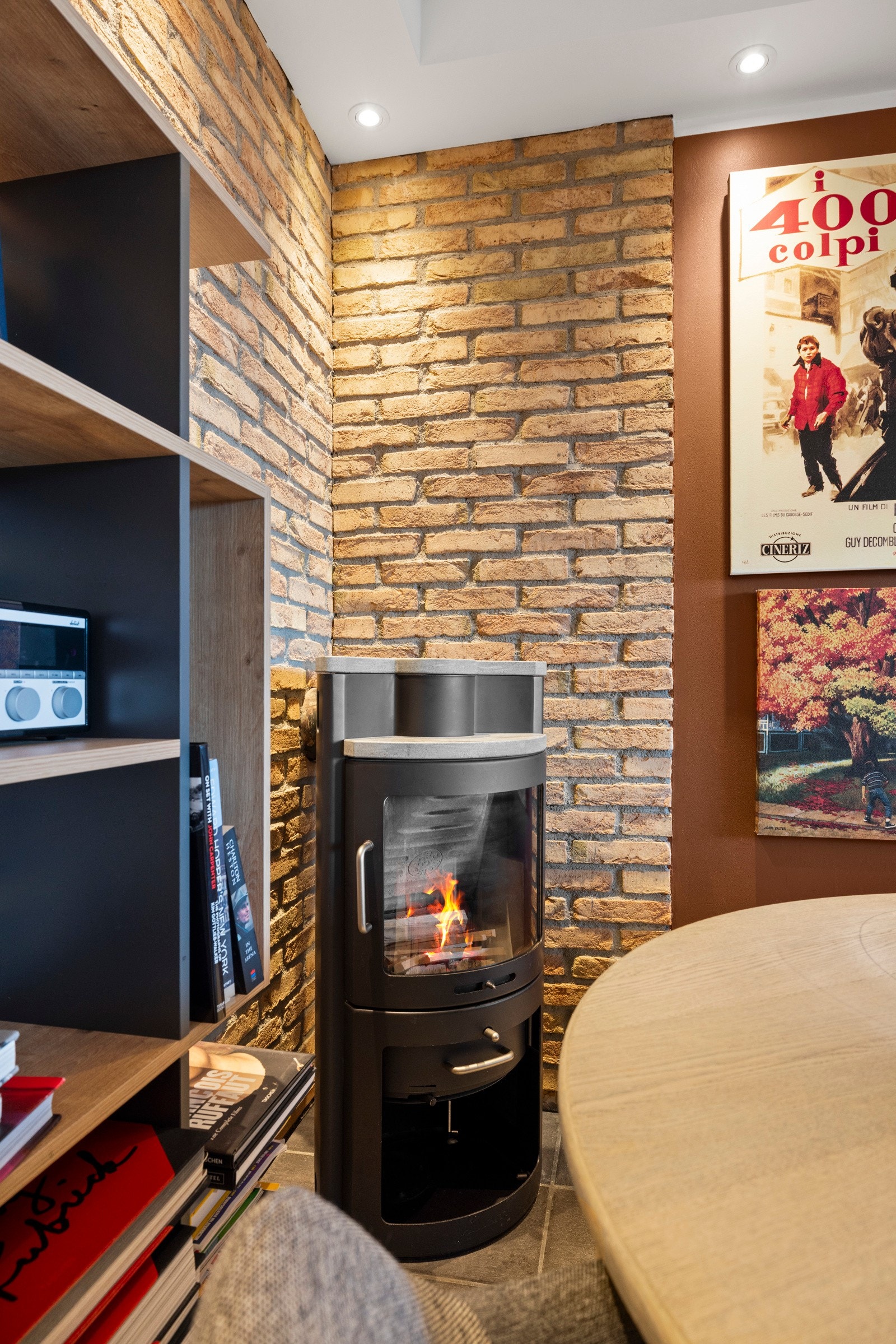 Innerst i hjørnet er det en peisovn med stort flammebilde Galleribilde