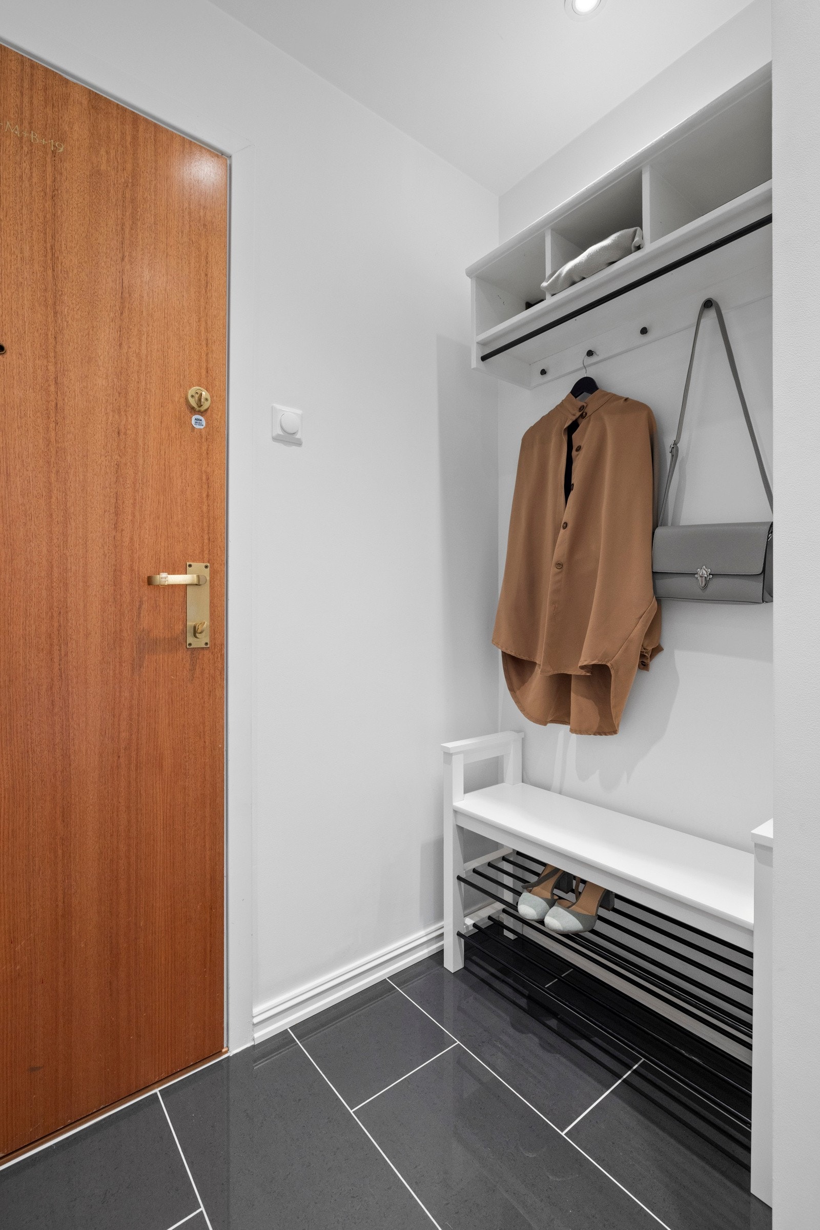 Like ved ytterdøren er det montert hattehylle med oppheng, og under er det plass til sittebenk med skohylle om ønskelig Galleribilde